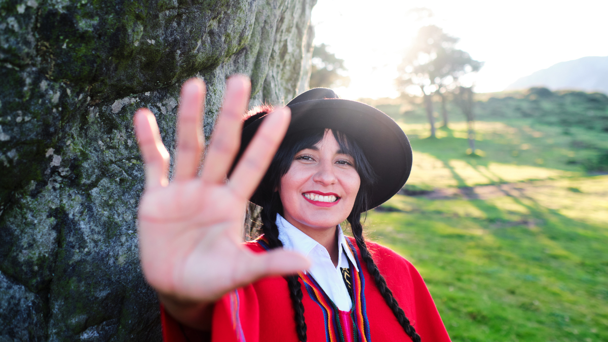 Image of Indigenous woman with palm facing out