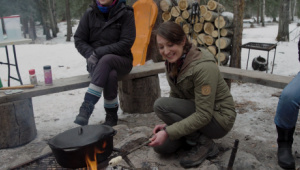 A guest at Painted Warriors Ranch cooks bannock over an open fire.