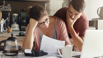 A concerned couple looking at a financial document.